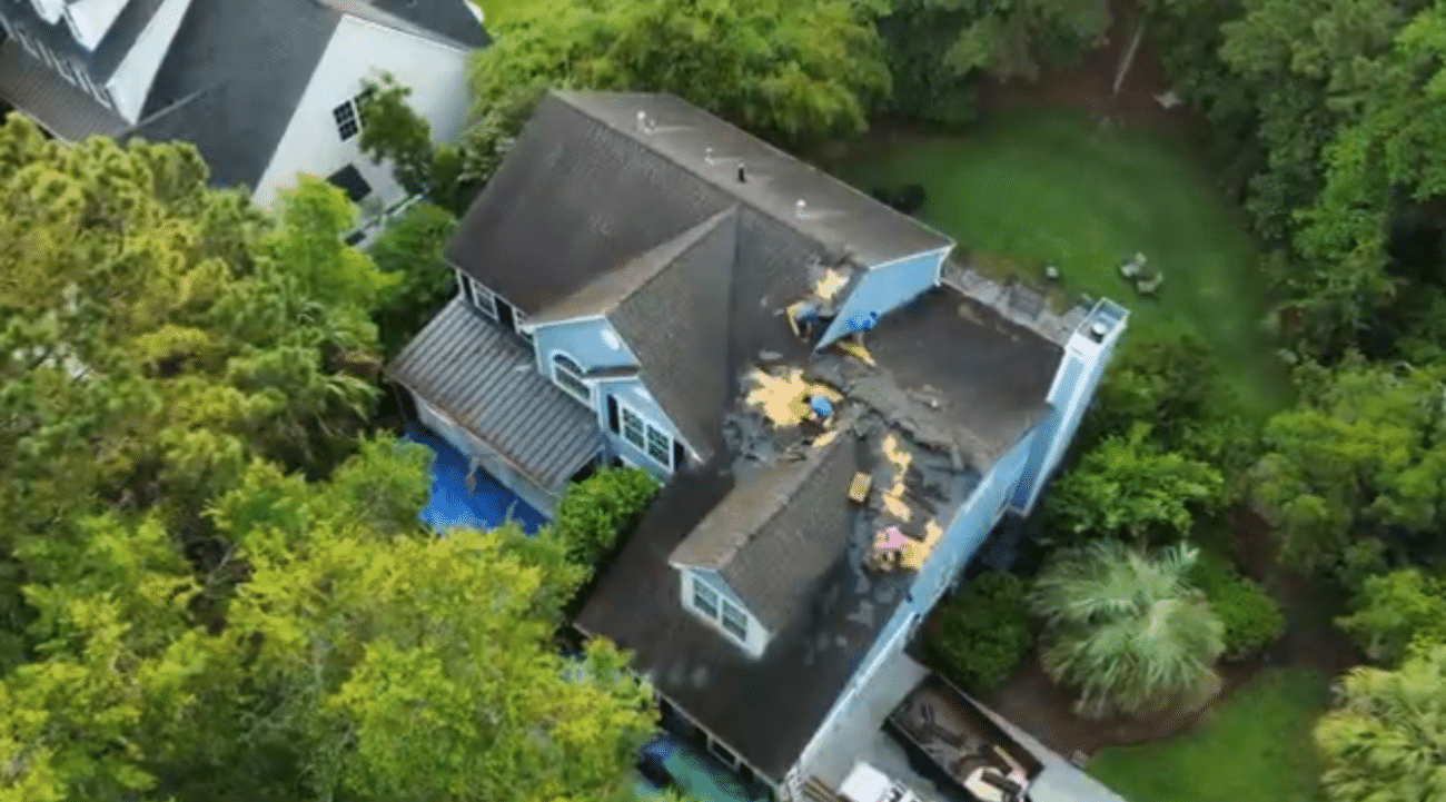 Roofing professional inspecting hurricane roof damage on a Lowcountry home